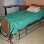 Matelas à air motorisé à pression alternée installé sur un lit médicalisé