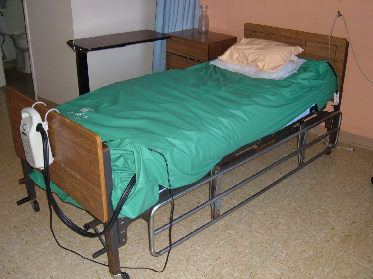 Matelas à air motorisé à pression alternée installé sur un lit médicalisé